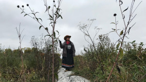 indigenous woman standing on pipeline