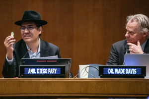From left to right: His Excellency Ambassador Diego Pary, Permanent Representative of Bolivia to the United Nations, seated and holding coca leaves in one hand, and Professor Wade Davis, PhD