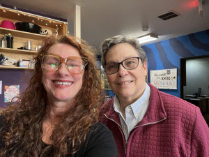 Two women smiling in a radio station lobby