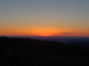 Looking West at Sunset The setting sun meets the dark horizon in the middle distance filling the upper portion of the image with a gradient that moves from smouldering orange to muddy water
