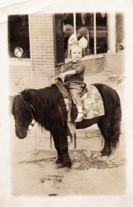 A picture of a child on a pony; the pony's blanket has the Self Help Radio logo on it.