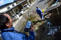 Takeshi Yamakawa of Tokyo Shimbun (black hair) and Iitate Village resident Nobuyoshi Ito (grey hair). Outdoor radiation air dose at this location in Iitate is 0.631 μSv/hour, almost 3x higher than the government limit of 0.23 μSv/hour. (Photo courtesy of 