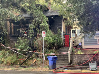 Image description: The home on Stark Street that was badly burned in a fire. The front of the house is charred black from fire damage.