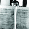 An old photo of a man holding a spectral music analysis printoff from a mainframe computer most likely